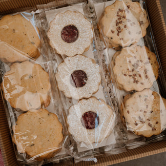 A gift box of assorted shortbread cookies with visible different flavors such as toffee and raspberry.